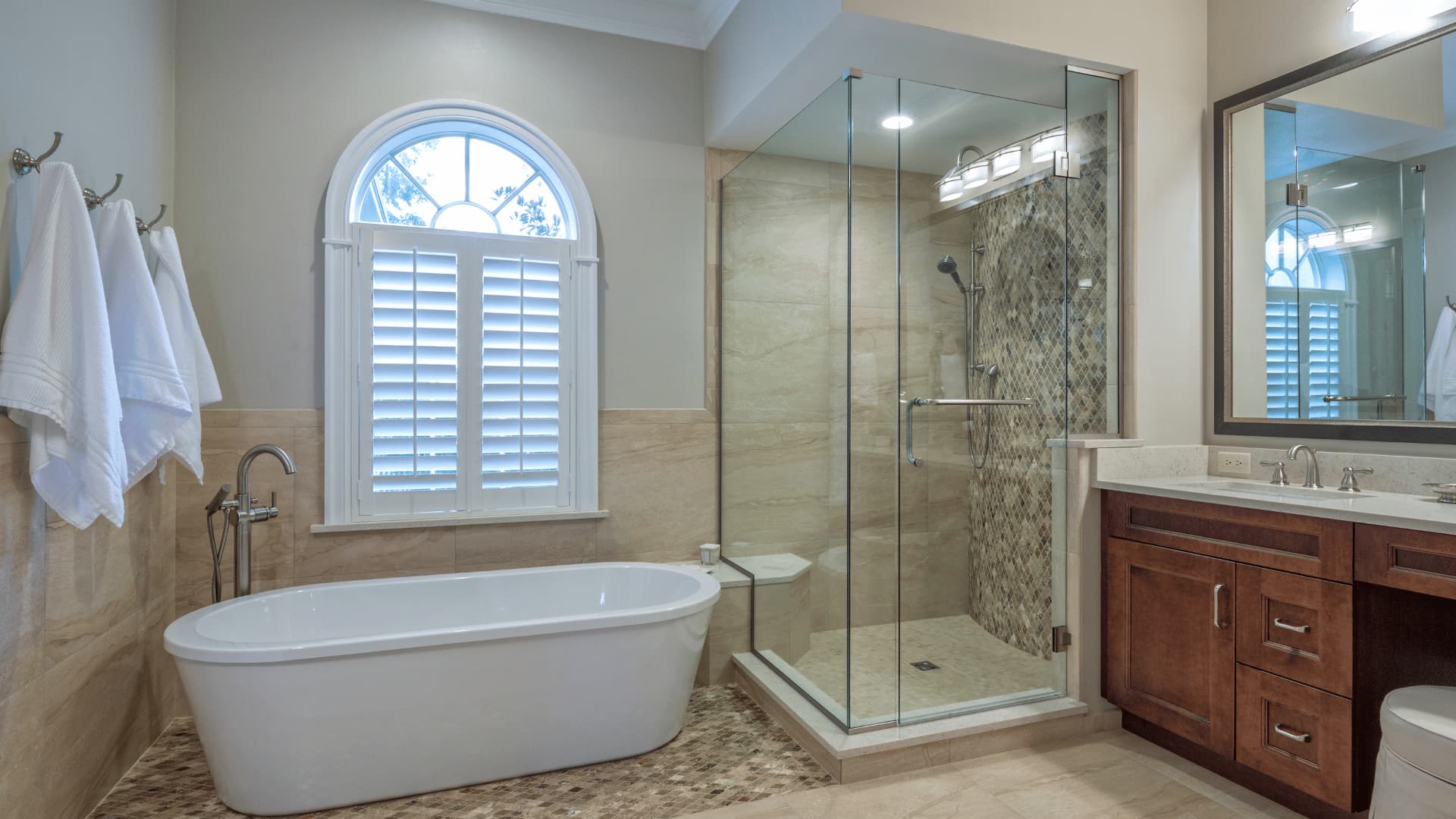 bathroom remodel features a sleek white bathtub alongside a stylish glass shower, creating a clean and contemporary look