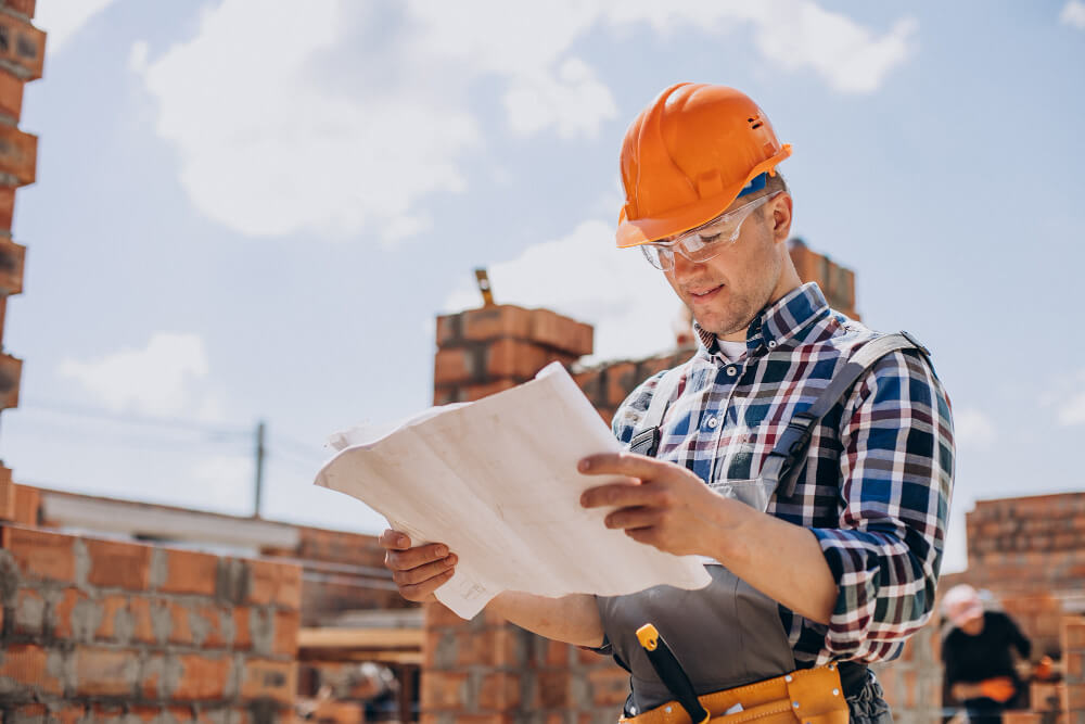Professional man holding a blueprint for ADU construction.