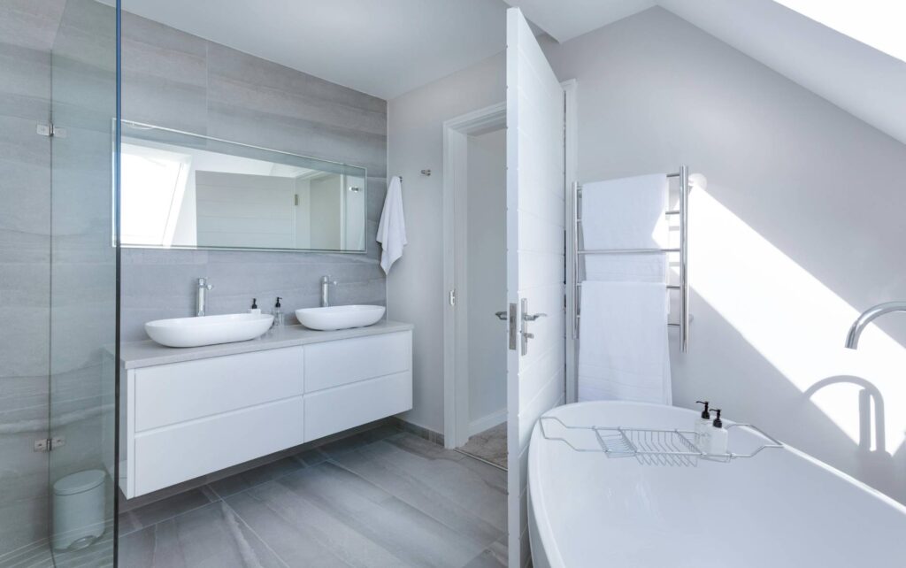 Los angeles bathroom remodel with all-white bathroom with a tub and twin sinks